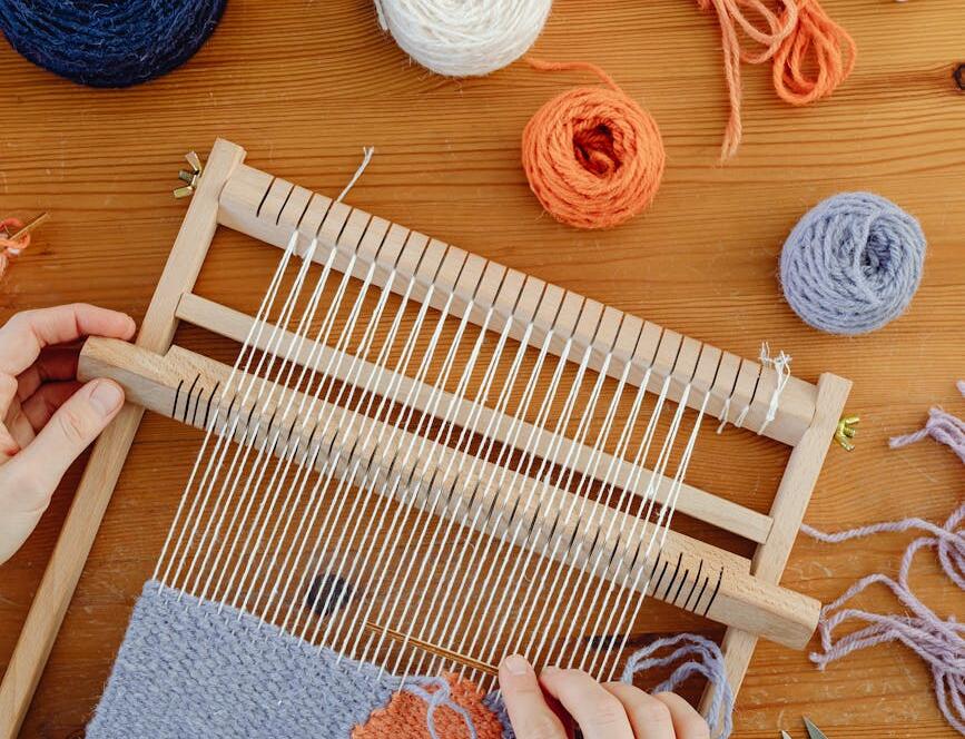 Close Up Of Woman Hands Making Craft Work With Wool And Loom
