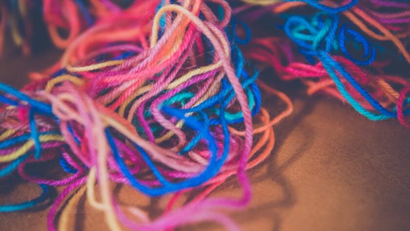 Blauwe en rode draad op bruin textiel